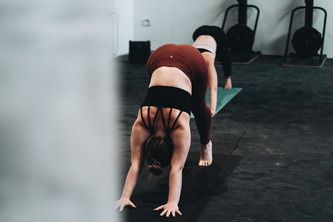 Dame træner og laver pike push-ups i et træningscenter