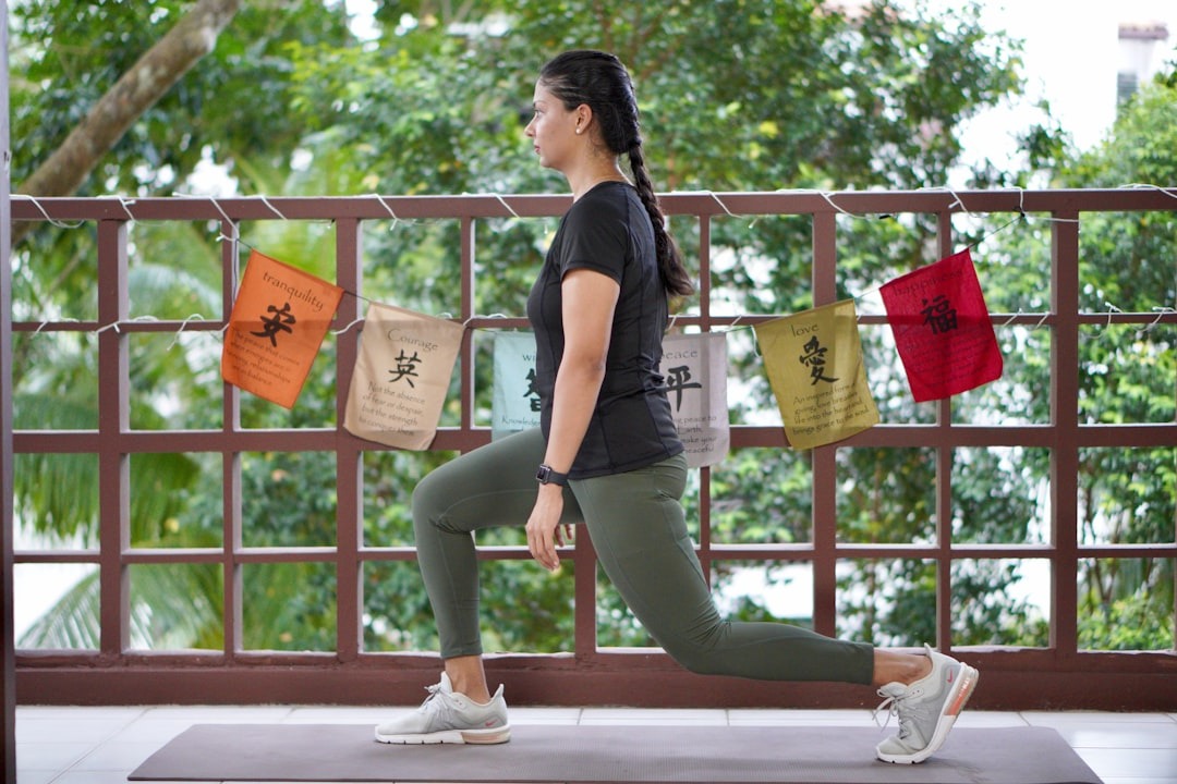 Kvinde laver lunges på en yogamåtte udenfor