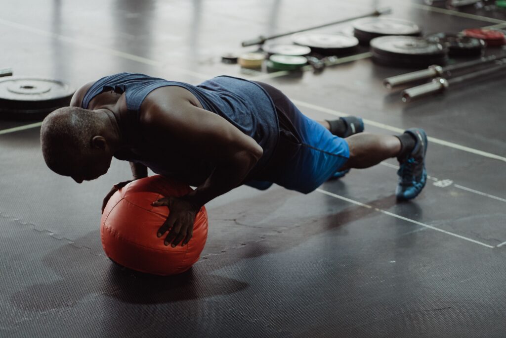 Man laver diamond push ups på en medicinbold 
