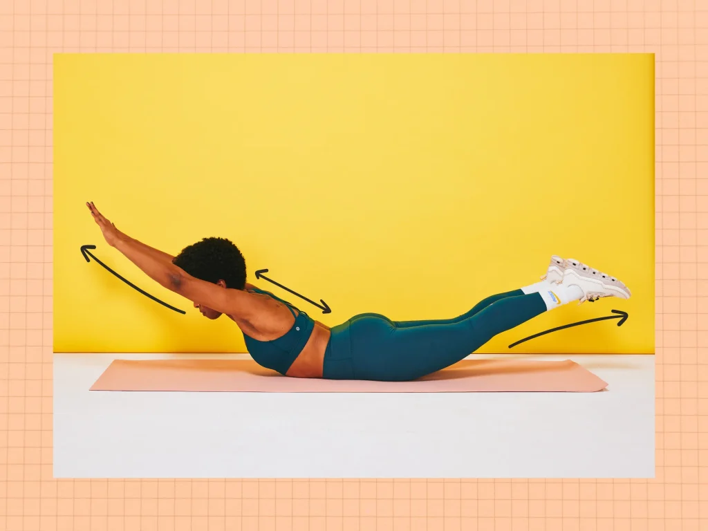 Kvinde laver superman øvelse på en yogamåtte