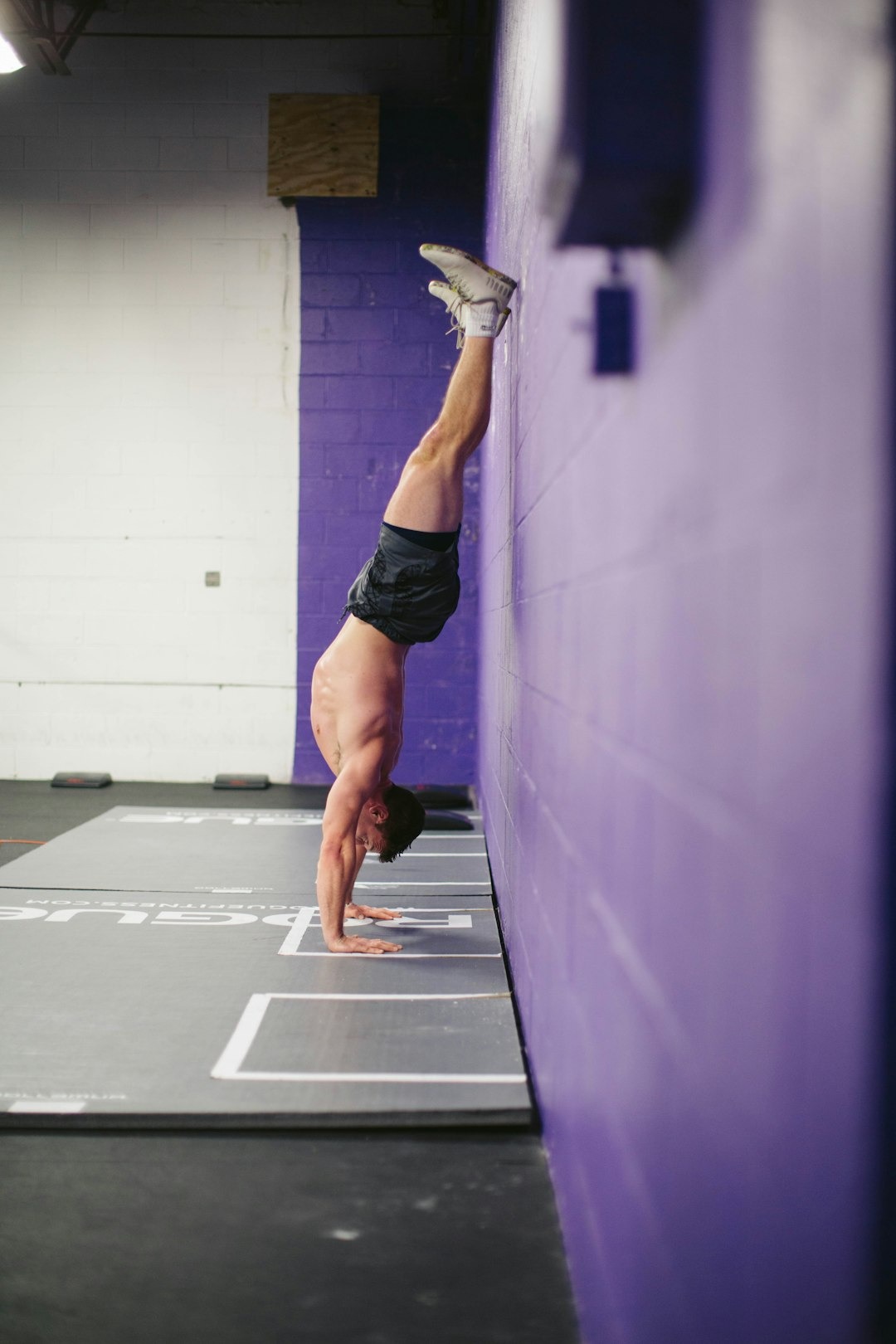 Mand står i en handstand position i et fitness center 